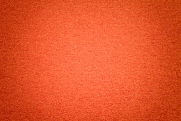 Texture of old red paper background, closeup. Structure of dense cardboard.