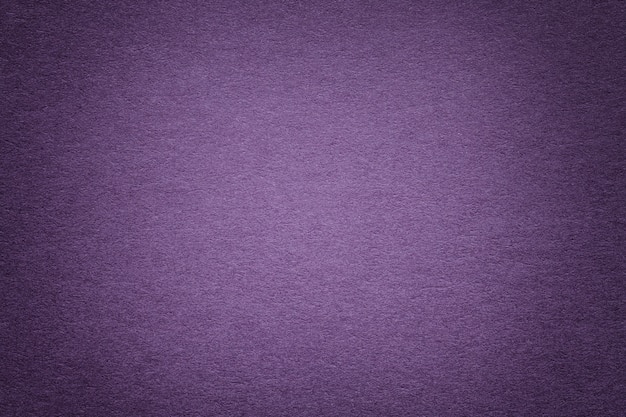 Texture of old violet paper background, closeup. Structure of dense cardboard.