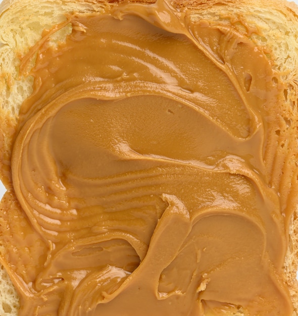 Photo texture of peanut butter spread on bread, full frame