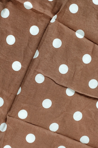 Texture of polka dot fabric is brown color background,Wavy folds of cloth. 