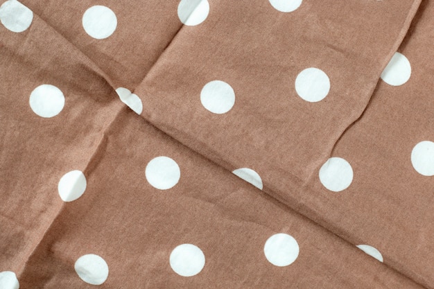 Texture of polka dot fabric is brown color background,Wavy folds of cloth. 
