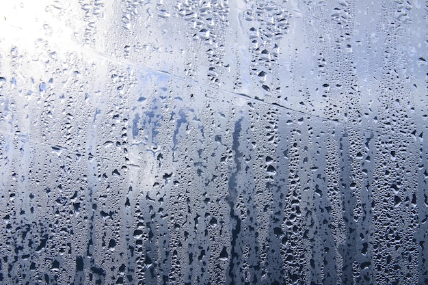 Texture of rain drops on wet transparent surface. Misted glass.