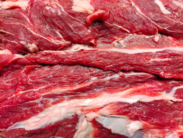 Texture of raw beef meat with streaks of lard on the full frame closeup