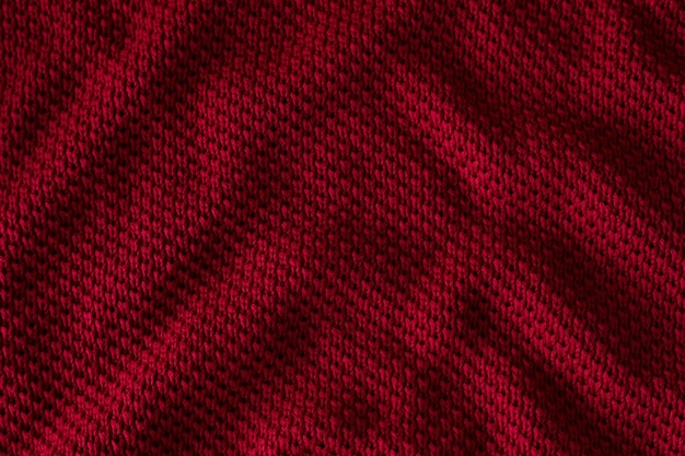 Texture of red knitted sweater closeup burgundy background