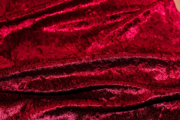 Photo texture of red velor corduroy fabric with folds