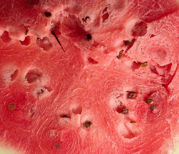 Texture of ripe red watermelon with brown seeds, full frame, close up