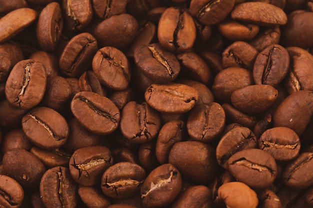 Texture of roasted coffee beans close-up, top view.