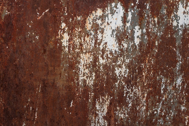 Photo texture of rusty old metal plate with cracked white paint.