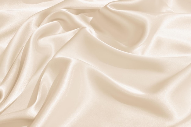 Photo the texture of the satin fabric of beige color for the background