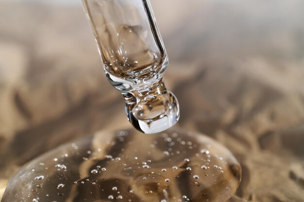 The texture of serum or oil with a pipette on a beige background