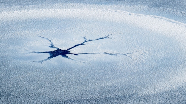 Texture of snow-covered ice with a small crack