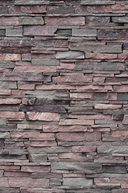 Texture of a stone wall from long and rough stones of different sizes and tones