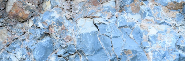 The texture of the surface of the gray blue natural stone rocks as a background. banner