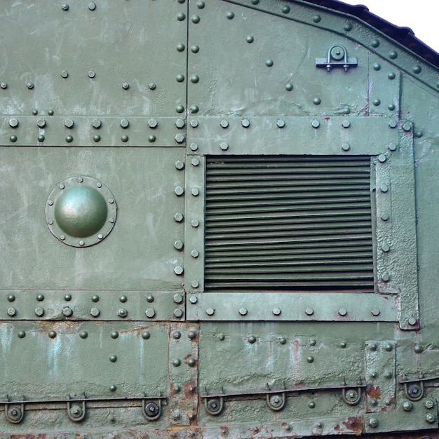 Texture of tank side wall, made of metal and reinforced with a multitude of bolts and rivets