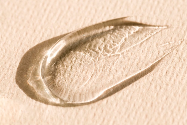 Texture of a transparent cosmetic product gel serum on a beige background Care product sample