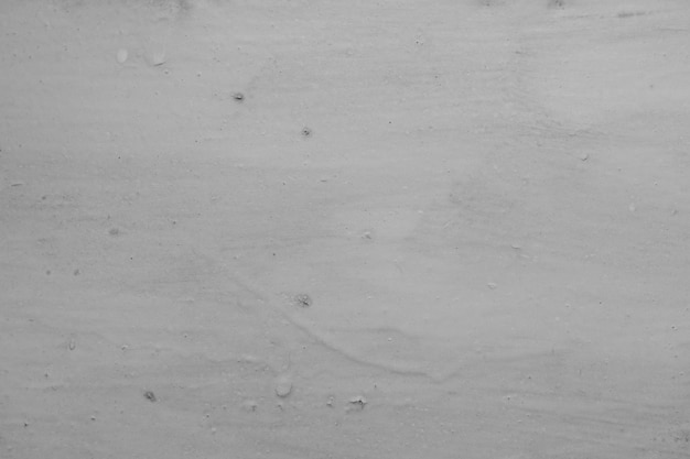 Texture of an unevenly plastered grey stonewall. Concrete wall with whitewash layer, background texture, whitewashed wall