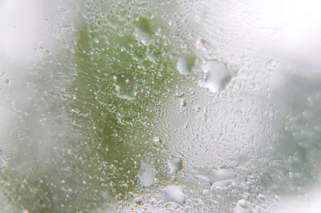 Texture of water drops with the blurred background of a window