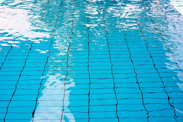 Struttura dell'acqua nella piscina vuota all'interno piscina per bambini piscina pubblica nel fitness club piscina per bambini con riflessi di sole