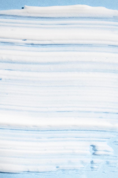 Texture of a white cosmetic product on a blue background top view