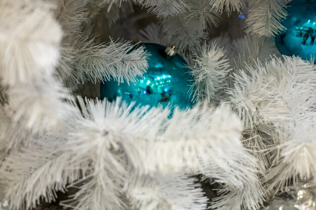 texture white fir branch with classic blue ball toy. a fragment of the New Year and Christmas tree. close-up, soft focus, blur background