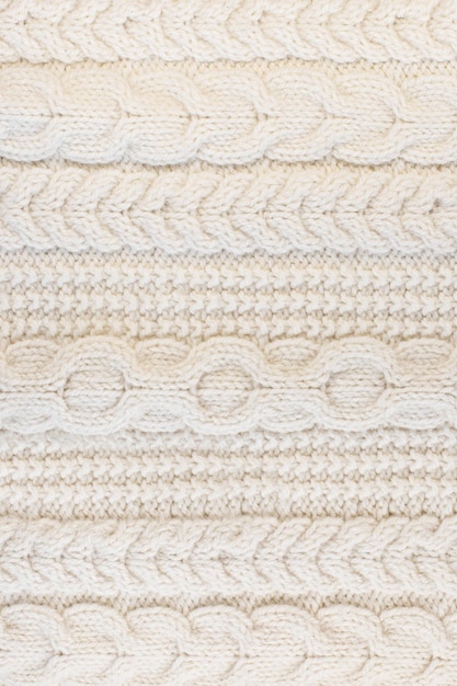 Texture of a winter chunky knit wool ivory color close-up. the fabric texture for your mockup