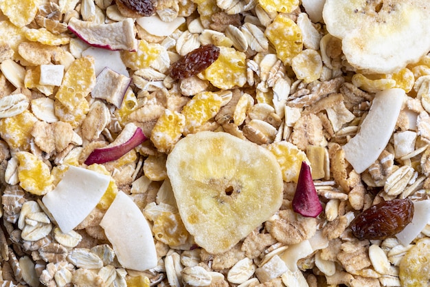 Texture with whole grains for breakfast. Macro close-up. Muesli with dried fruits and dried fruits. Horizontal portrait.