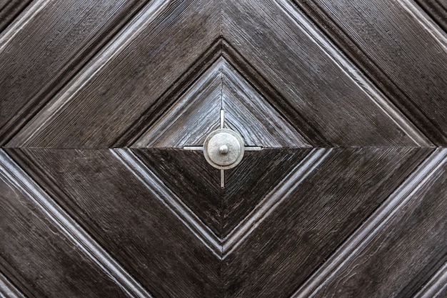 The texture of the wooden surface of the entrance door is brown.