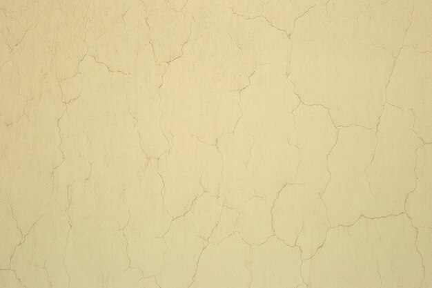 Texture of yellow old stucco with cracks Cracked stucco wall background