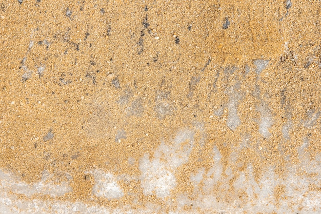 Texture of yellow sand on white ice. Sand is poured onto ice for safe movement, pedestrian care, traffic safety.