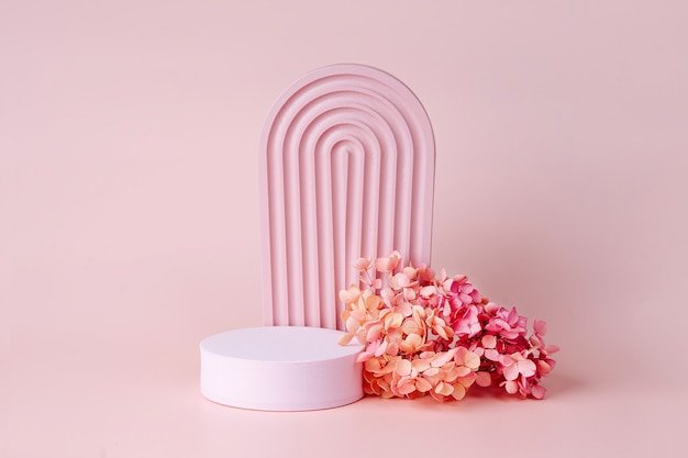 Textured  arch  with podium and  flowers on a pink background