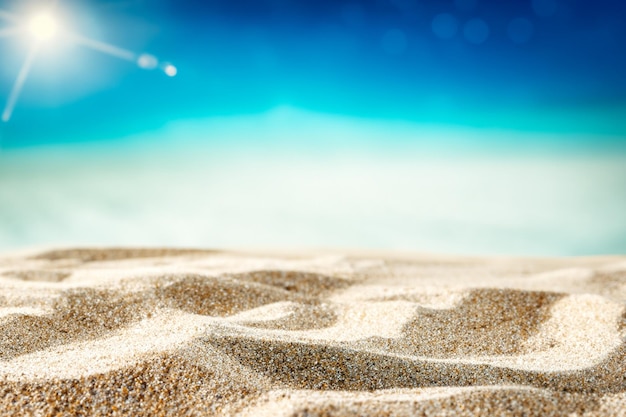 Textured beach sand with tropical summer sky in background