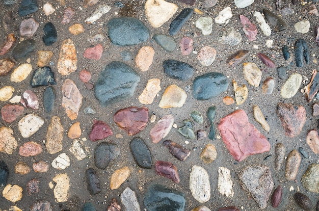 背景の織り目加工の美しい自然の抽象的な表面丸い石で石を敷石
