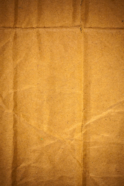 Текстурированная предпосылка мятой коричневой картонной бумаги.
