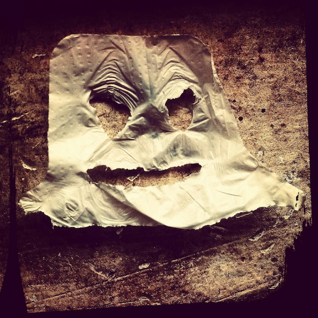 Фото Текстурированный эффект скрученной бумаги, превращенной в страшное лицо.