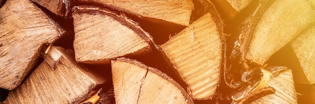 Fondo strutturato della legna da ardere di legno tagliato per accendere e riscaldare la casa una catasta di legna con legna da ardere impilata. la trama dell'albero di betulla. bandiera. bagliore
