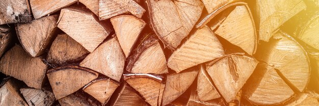 Fondo strutturato della legna da ardere di legno tagliato per accendere e riscaldare la casa una catasta di legna con legna da ardere impilata. la trama dell'albero di betulla. bandiera. bagliore