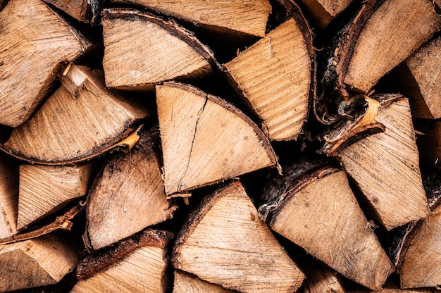 Textured firewood background of chopped wood for kindling and heating the house. a woodpile with stacked firewood. the texture of the birch tree