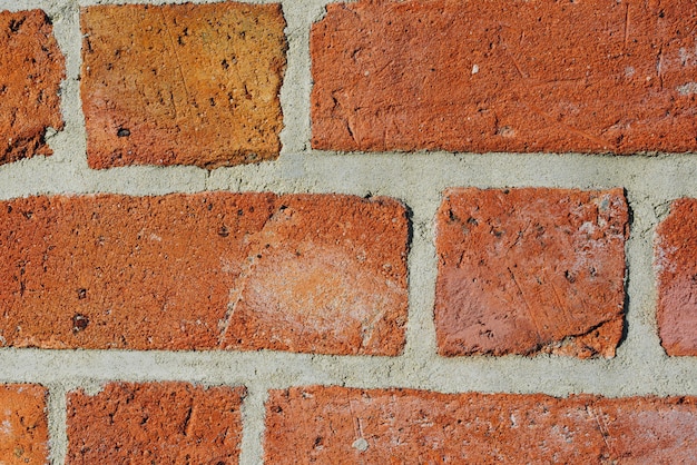 Textured red brick wall background or backdrop, rectangular red terracotta bricks laid out as pattern, architectural structure for old rough building. High quality photo