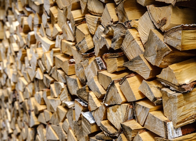 A textured solid background at an angle of birch firewood folded in a dense stack extending into the distance