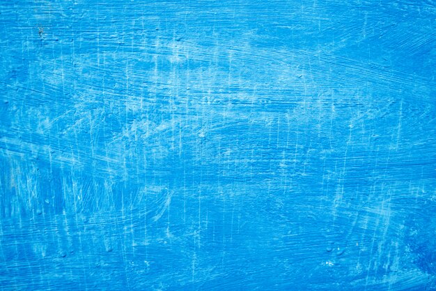 textured strokes of blue paint on the wooden surface. 