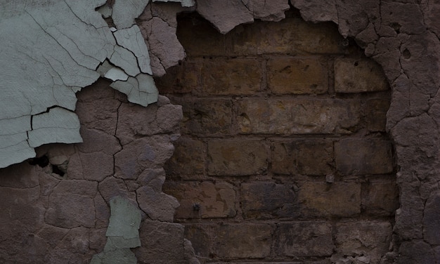 Textured wall with falling plaster and old brick