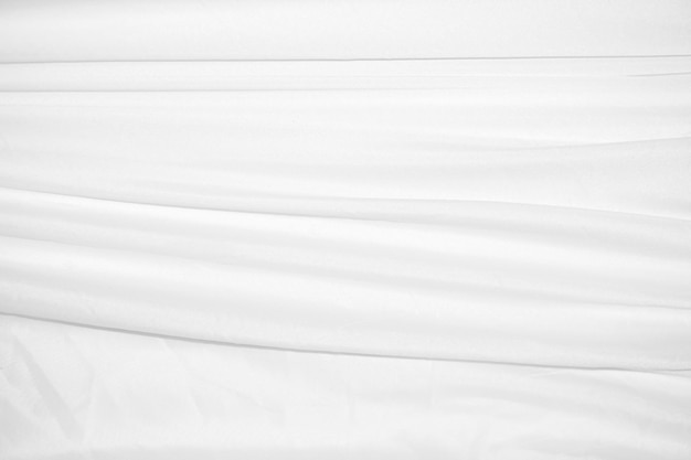 Texturen Achtergrond Het abstracte achtergrondpatroon van witte stof met zachte golven is geschikt voor een jurk of pak waar transparantie en vloeiendheid vereist zijn