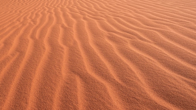 Textuur en achtergrond van een zandduin met sporen van de wind in de woestijn