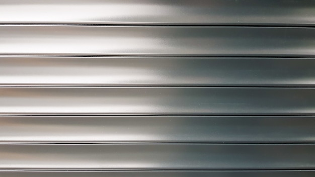 Textuur jaloezieën of roleta. horizontale metalen jaloezieën poorten gesloten gestreept zilver. aluminium metalen textuur abstracte achtergrond.