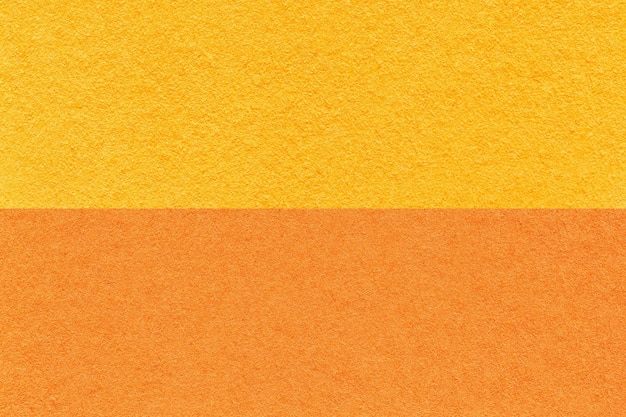 Textuur van ambachtelijk oranje en geel papier achtergrond half twee kleuren macro Structuur van vintage gember karton