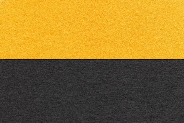 Textuur van ambachtelijk zwart en geel papier achtergrond half twee kleuren macro Structuur van vintage ambachtelijk karton