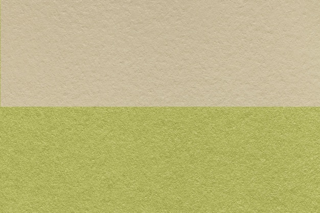 Textuur van ambachtelijke licht beige en groen papier achtergrond half twee kleuren macro Vintage kraft olijf karton