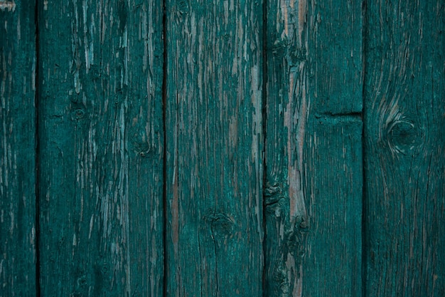 textuur van een houten hek. hek groen geschilderd. afbladderende verf op een oud hek. oude houtstructuur.