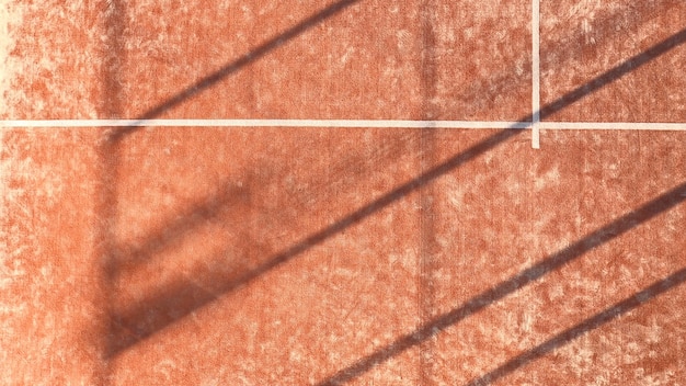 Textuur van een outdoor paddle-tennisbaan van bovenaf gezien. Oranje hof met witte lijnen.