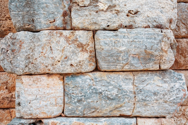 Foto textuur van een stenen muur gemaakt van grote blokken, elementen van het gebouw van de oude oudheid.